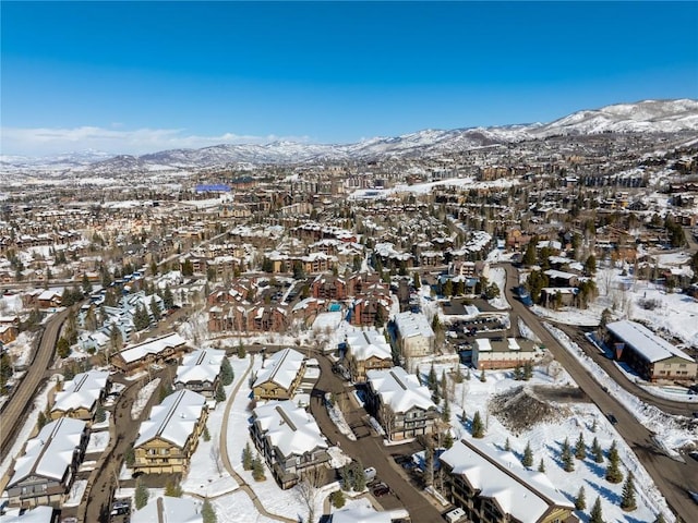 snowy aerial view featuring a residential view and a mountain view