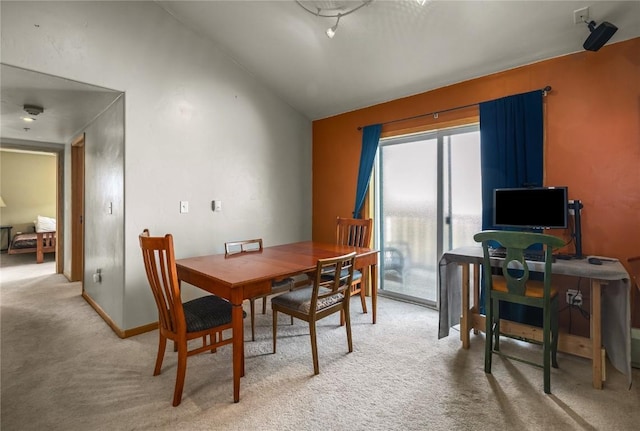 dining area featuring baseboards, light colored carpet, and vaulted ceiling