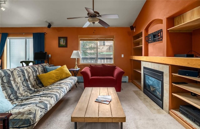 carpeted living area with a tiled fireplace, built in features, ceiling fan, and a baseboard radiator