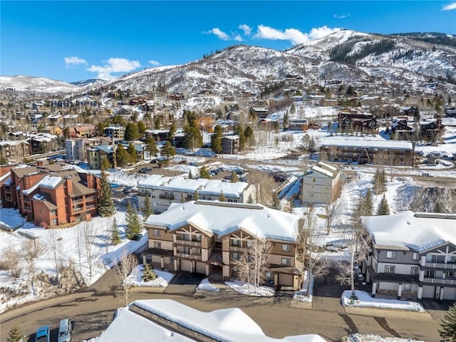 snowy aerial view with a mountain view and a residential view