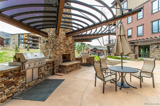 view of patio with an outdoor stone fireplace, a pergola, area for grilling, and a grill