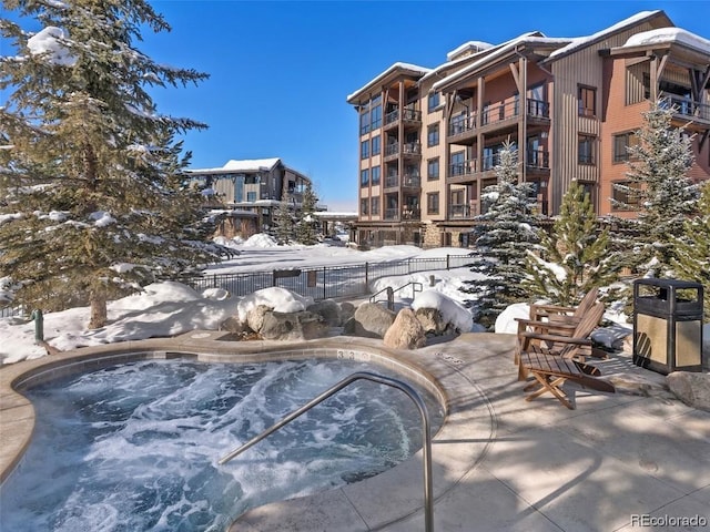 snow covered pool featuring a jacuzzi