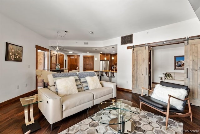 living room featuring a barn door and dark hardwood / wood-style flooring