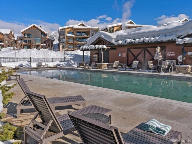 snow covered pool featuring a patio area