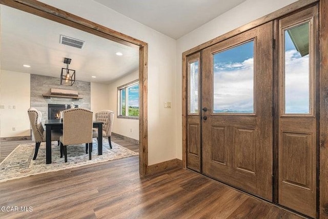 foyer featuring a fireplace and dark wood-type flooring