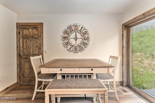 dining area with a wealth of natural light and hardwood / wood-style floors