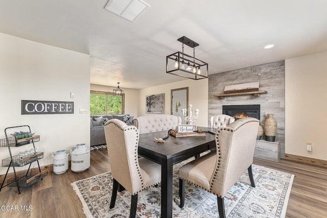 dining area featuring hardwood / wood-style flooring and a fireplace