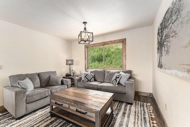 living room with dark hardwood / wood-style flooring and a notable chandelier