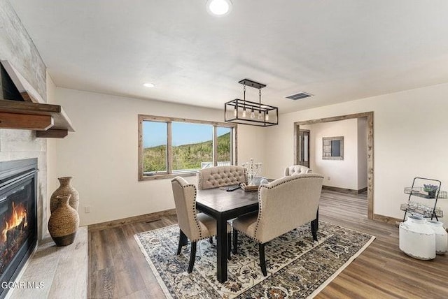 dining area with a large fireplace and dark wood-type flooring