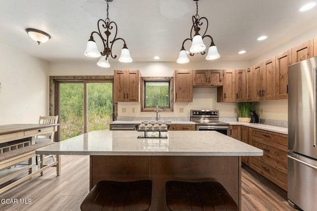 kitchen featuring hardwood / wood-style floors, stainless steel appliances, decorative light fixtures, and a notable chandelier