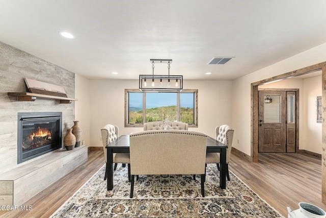 dining area with a fireplace and hardwood / wood-style floors