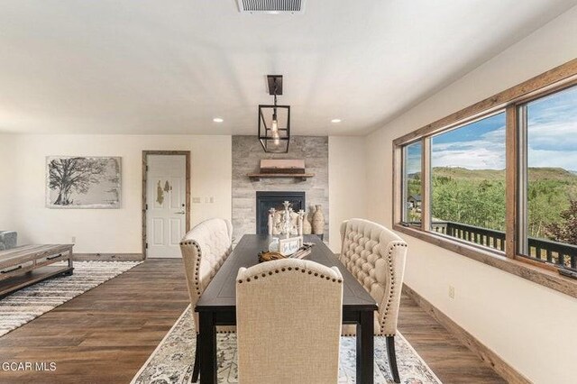 dining area with a fireplace and dark wood-type flooring