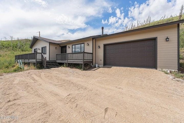 ranch-style house with a deck and a garage