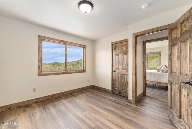 unfurnished bedroom featuring dark hardwood / wood-style flooring and multiple windows