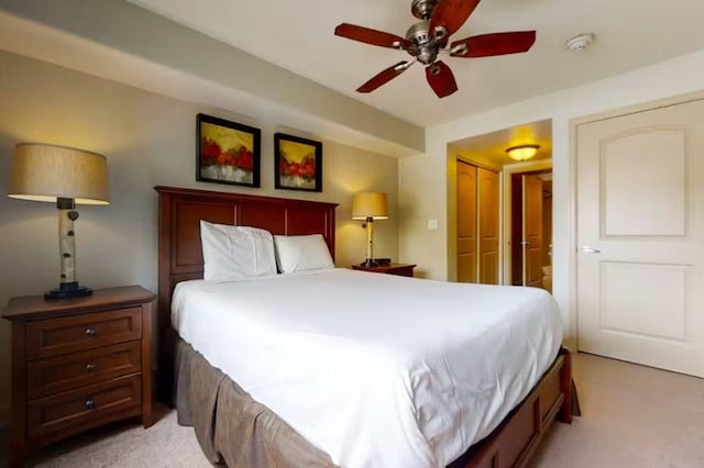 bedroom featuring ceiling fan, a closet, and light colored carpet