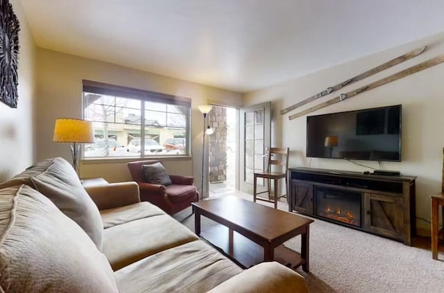 carpeted living room with a glass covered fireplace