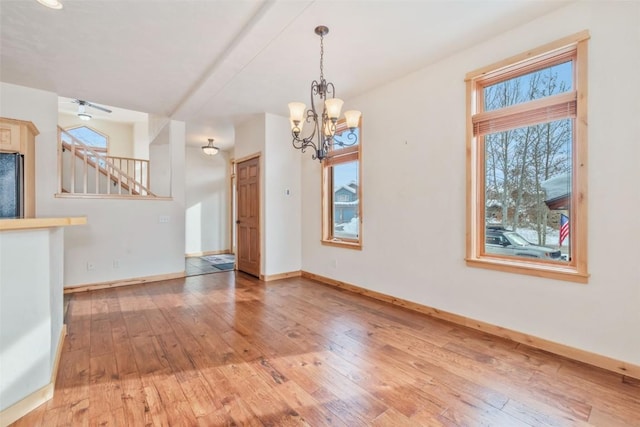 unfurnished dining area featuring hardwood / wood-style floors and a notable chandelier