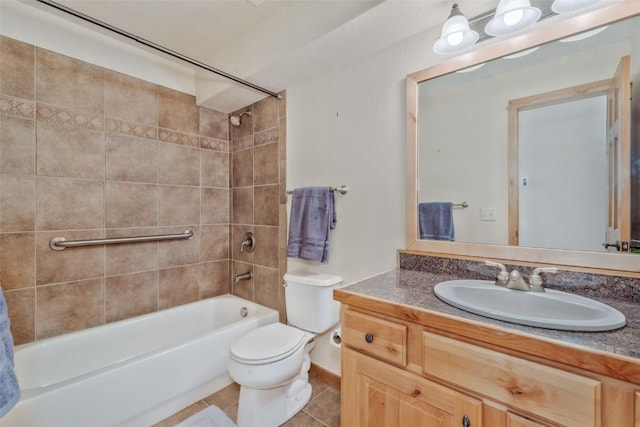 full bathroom with tiled shower / bath, toilet, tile patterned floors, and vanity