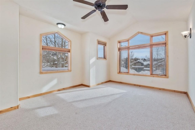 spare room featuring lofted ceiling, light colored carpet, and a healthy amount of sunlight