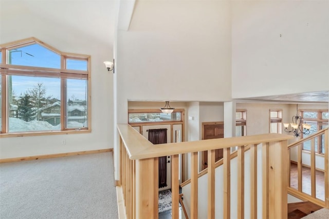 stairs with carpet floors and a notable chandelier