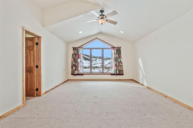 interior space with vaulted ceiling, light colored carpet, and ceiling fan