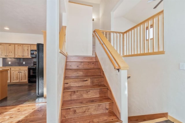 stairway featuring hardwood / wood-style floors and vaulted ceiling