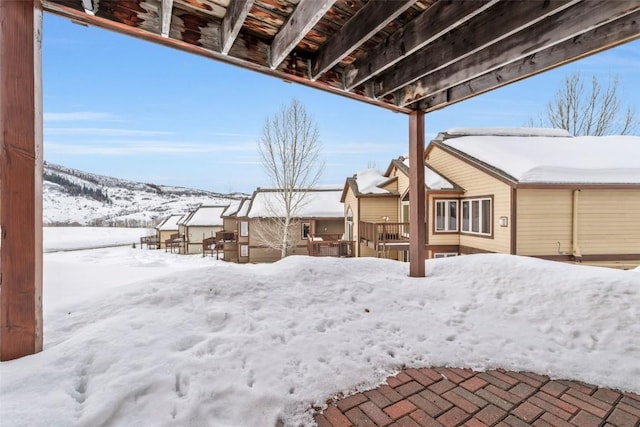 yard covered in snow with a deck with mountain view