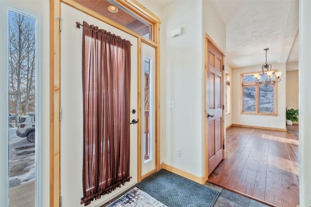 foyer with wood-type flooring and a chandelier