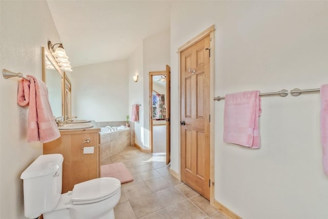 bathroom with vanity, a relaxing tiled tub, tile patterned floors, and toilet