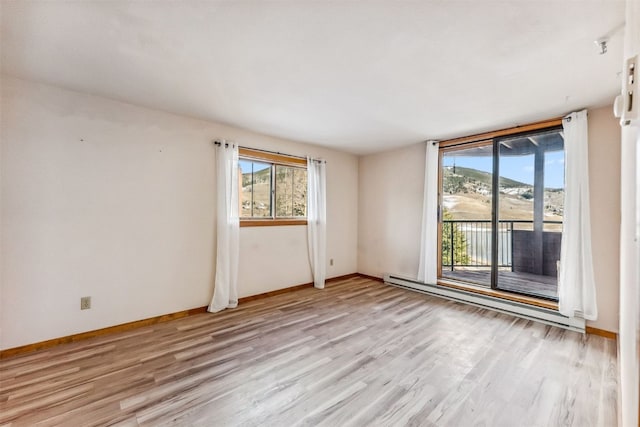 empty room featuring a baseboard radiator and light wood-type flooring