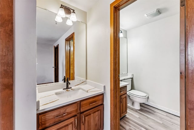 bathroom featuring hardwood / wood-style flooring, vanity, and toilet