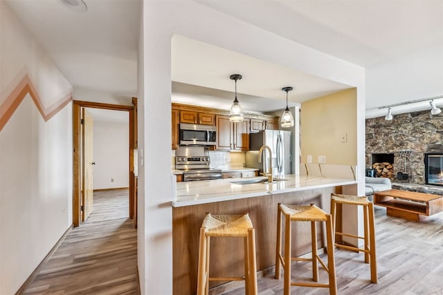 kitchen with a kitchen breakfast bar, kitchen peninsula, sink, and appliances with stainless steel finishes