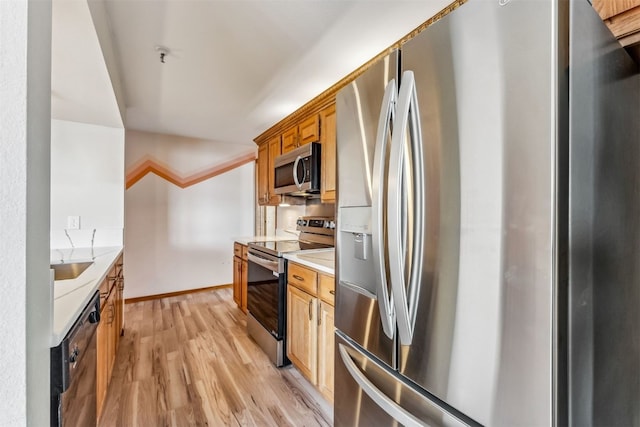 kitchen with sink, light wood-type flooring, and appliances with stainless steel finishes