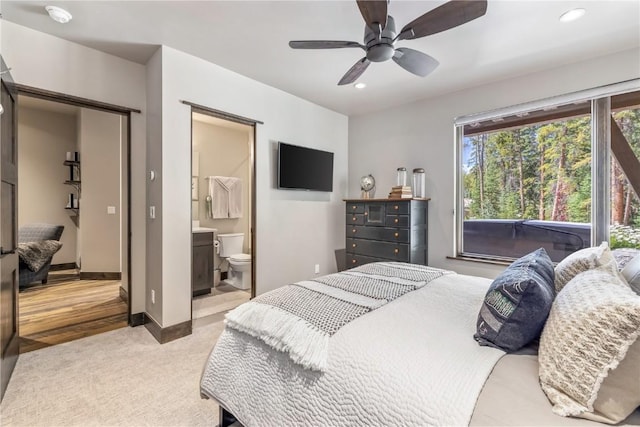 carpeted bedroom with ceiling fan and ensuite bathroom