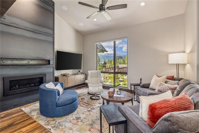 living room with ceiling fan, hardwood / wood-style floors, and lofted ceiling