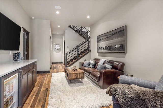 living room with bar, wine cooler, and dark wood-type flooring