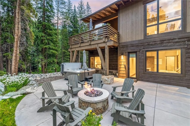 patio terrace at dusk with a balcony and a fire pit