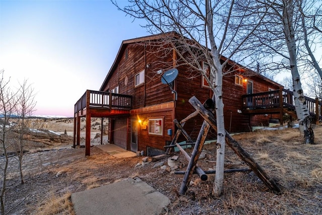 exterior space with a garage, driveway, and a wooden deck