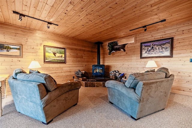 living area with wooden ceiling, carpet flooring, a wood stove, and rail lighting