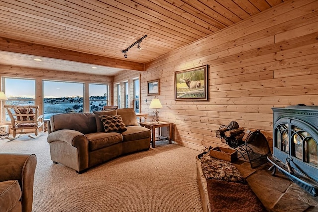 carpeted living area with a wood stove, wood walls, wood ceiling, beamed ceiling, and rail lighting