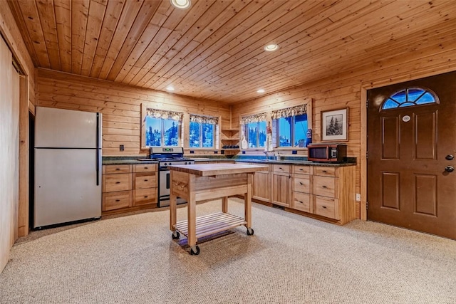 kitchen with dark countertops, wood ceiling, stainless steel appliances, and light brown cabinetry