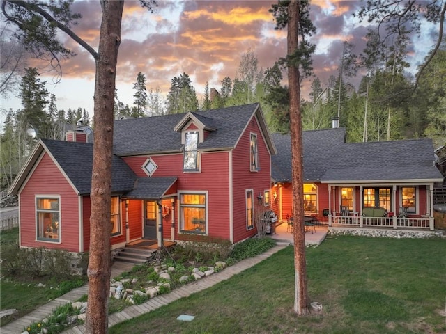 view of front of home with a patio area and a yard