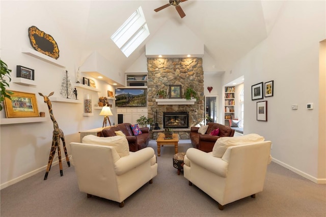 living room with light carpet, high vaulted ceiling, a skylight, ceiling fan, and a fireplace