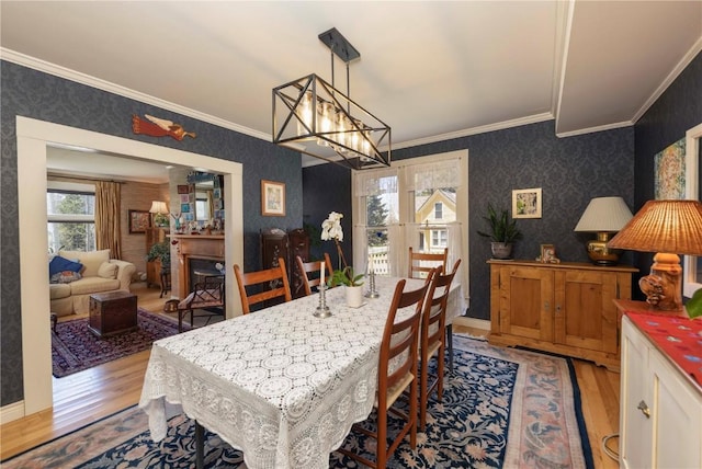 dining space with crown molding, a chandelier, and light wood-type flooring