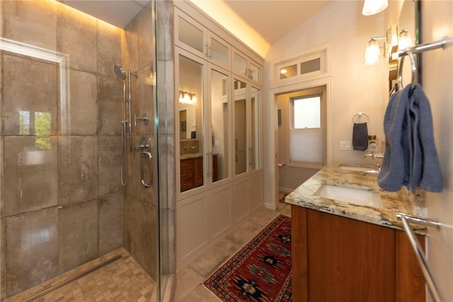 bathroom featuring a shower with door, vanity, and lofted ceiling