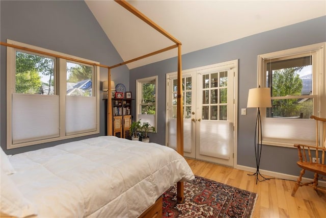 bedroom featuring hardwood / wood-style floors, vaulted ceiling, and french doors