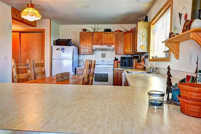 kitchen with range, white fridge, decorative light fixtures, and sink