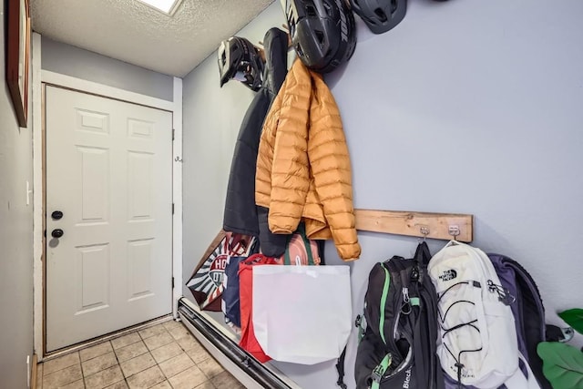 mudroom with light tile patterned floors and a textured ceiling