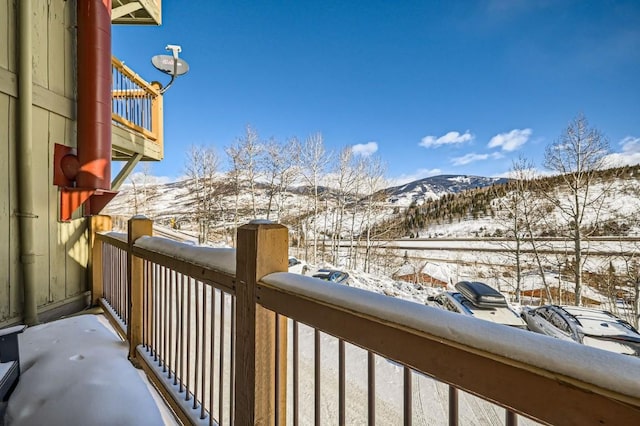 snow covered back of property featuring a mountain view