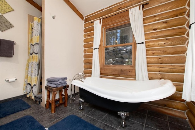 bathroom with a washtub and log walls